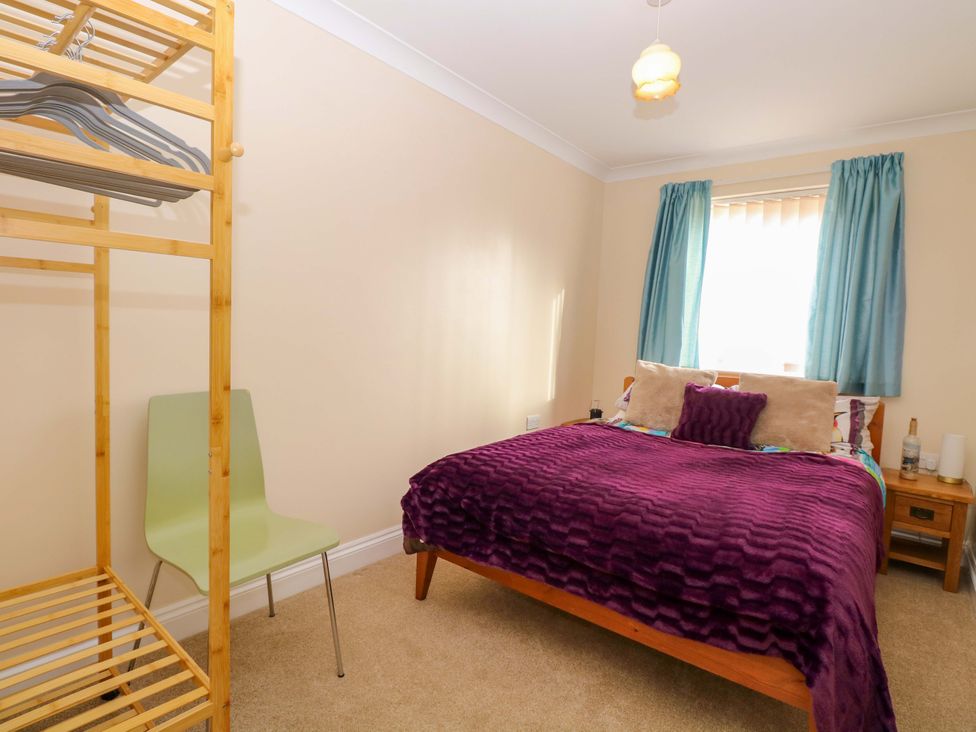 A bedroom with a bed and a clothes rack at The Bungalow 