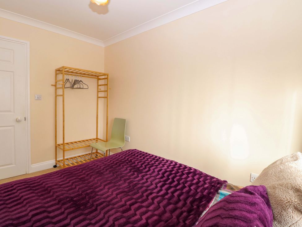 A bedroom with a bed and shelving unit at The Bungalow