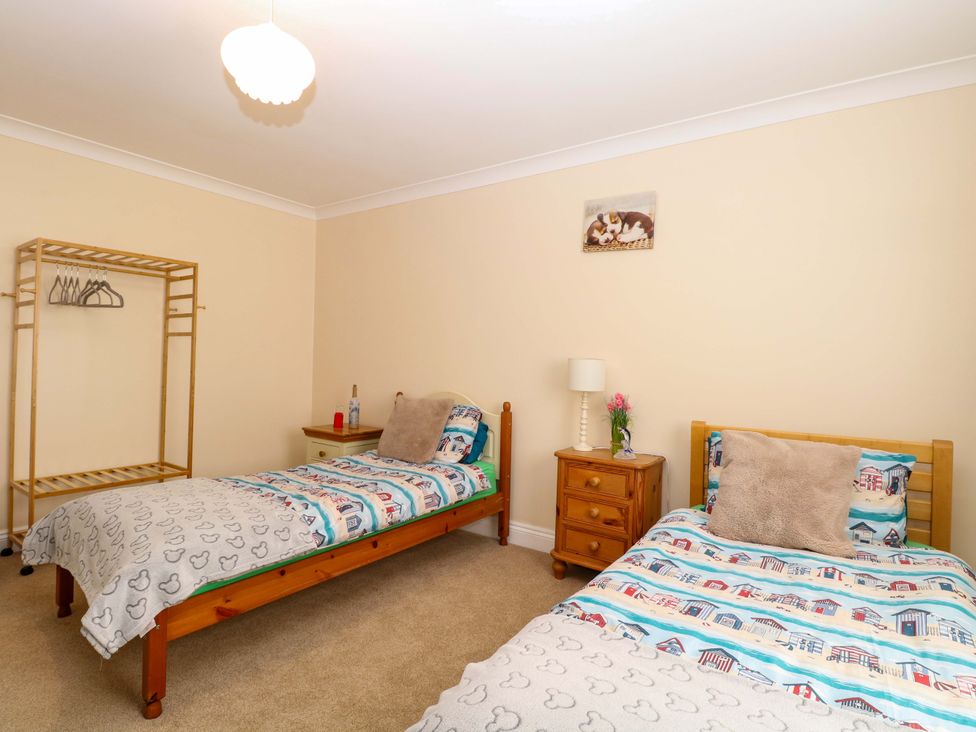 A bedroom with two beds and a clothes rack at The Bungalow in 
