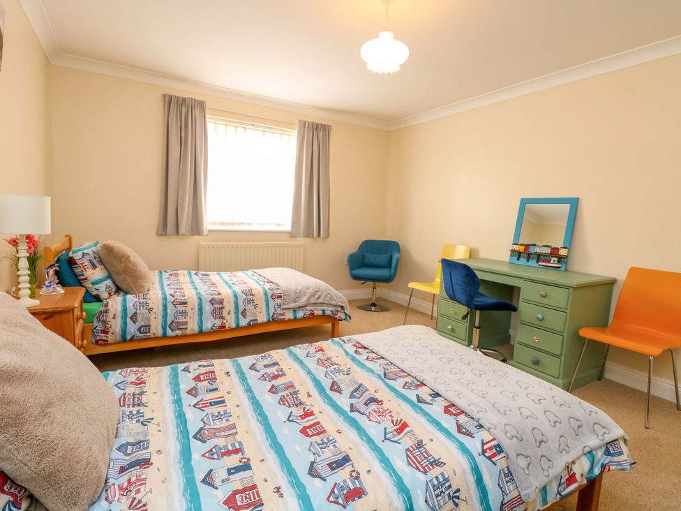 A bedroom with two beds and a desk at The Bungalow 
