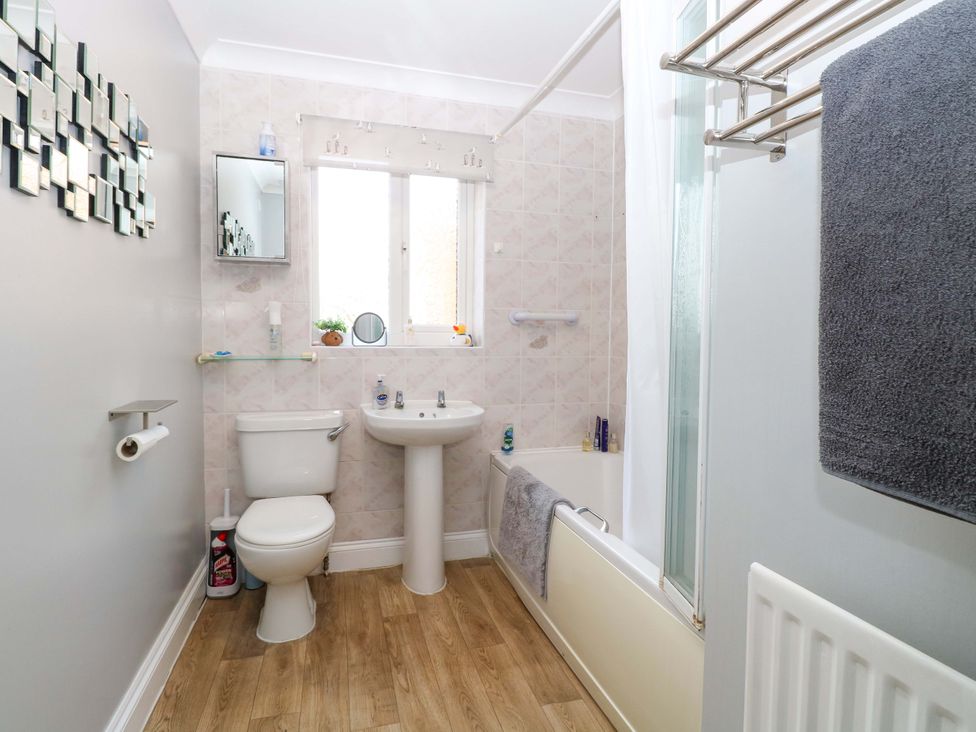 A bathroom with a sink, toilet, and shower area at The Bungalow