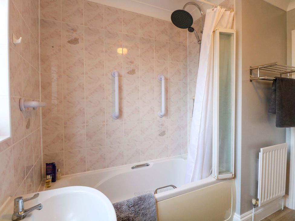 A bathroom with a bathtub and shower at The Bungalow