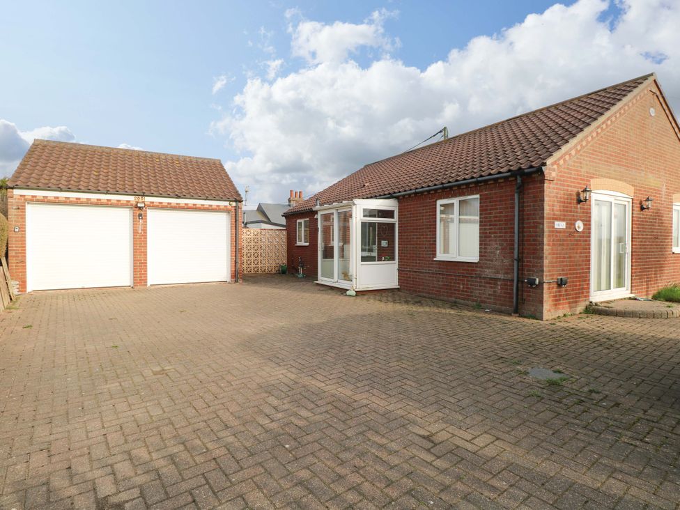 A house with a garage and paved driveway at The Bungalow 