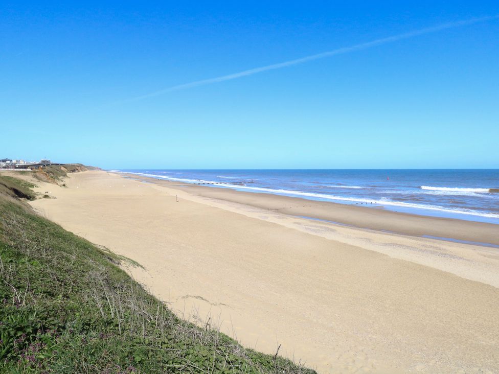A beach with sand and ocean under a clear sky at The Bungalow 