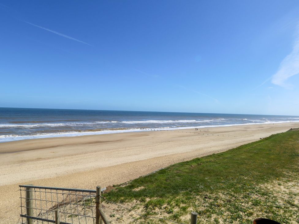 A beach with sand and ocean waves at The Bungalow in 