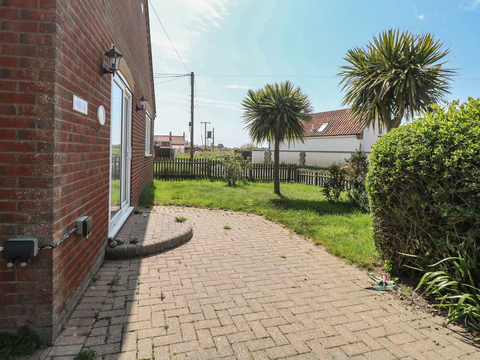A garden with a pathway and plants at The Bungalow in Walcott
