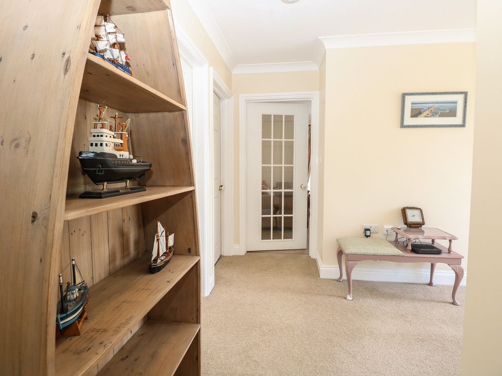 A hallway with a bookshelf and models at The Bungalow in Walcott