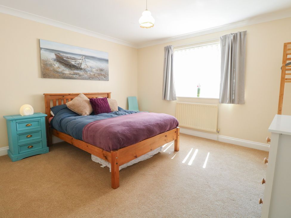 A bedroom with a bed and nightstand at The Bungalow in Walcott