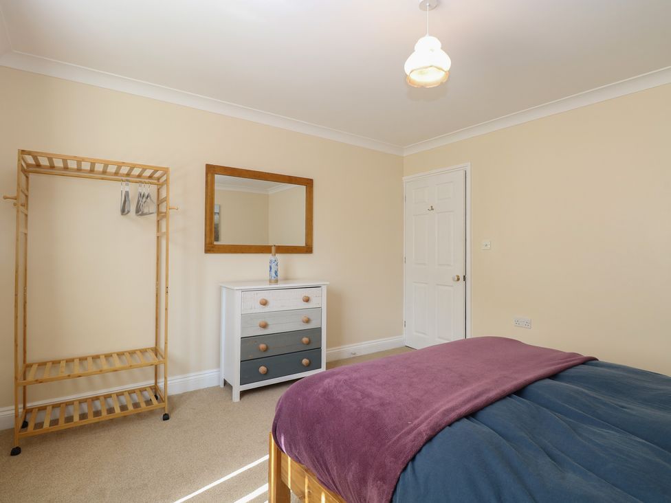 A bedroom with a bed, mirror, and a wardrobe at The Bungalow in Walcott