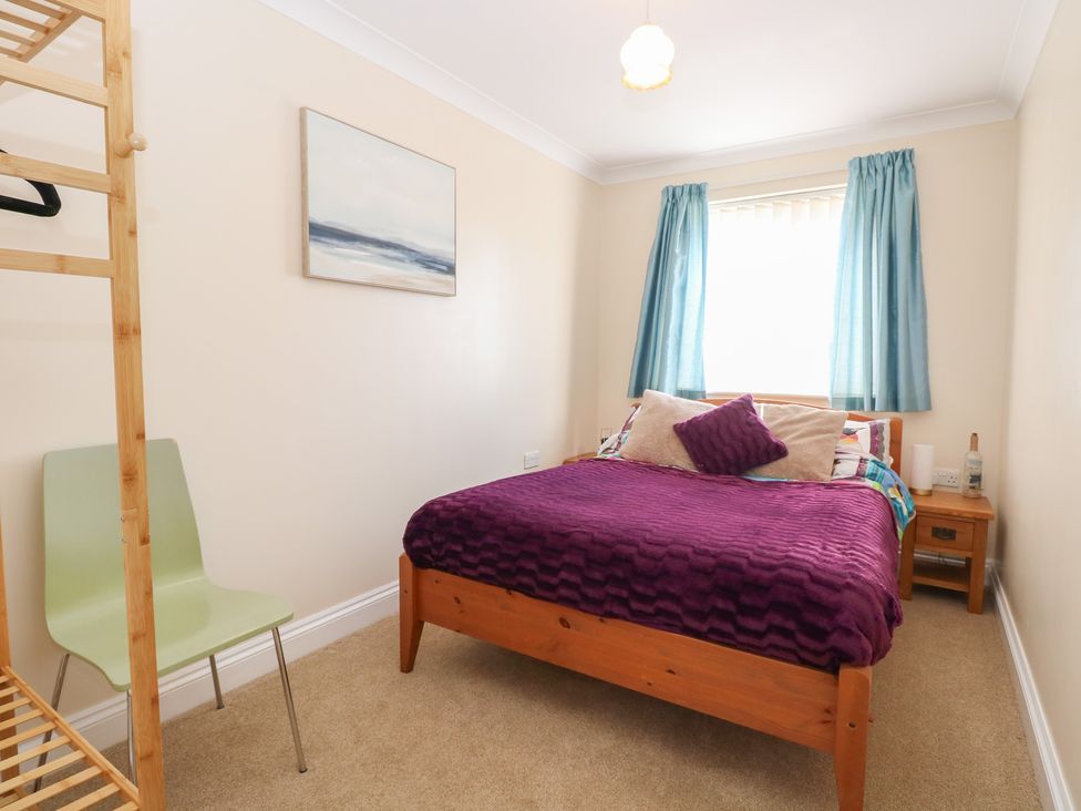 A bedroom with a bed and a chair at The Bungalow in Walcott