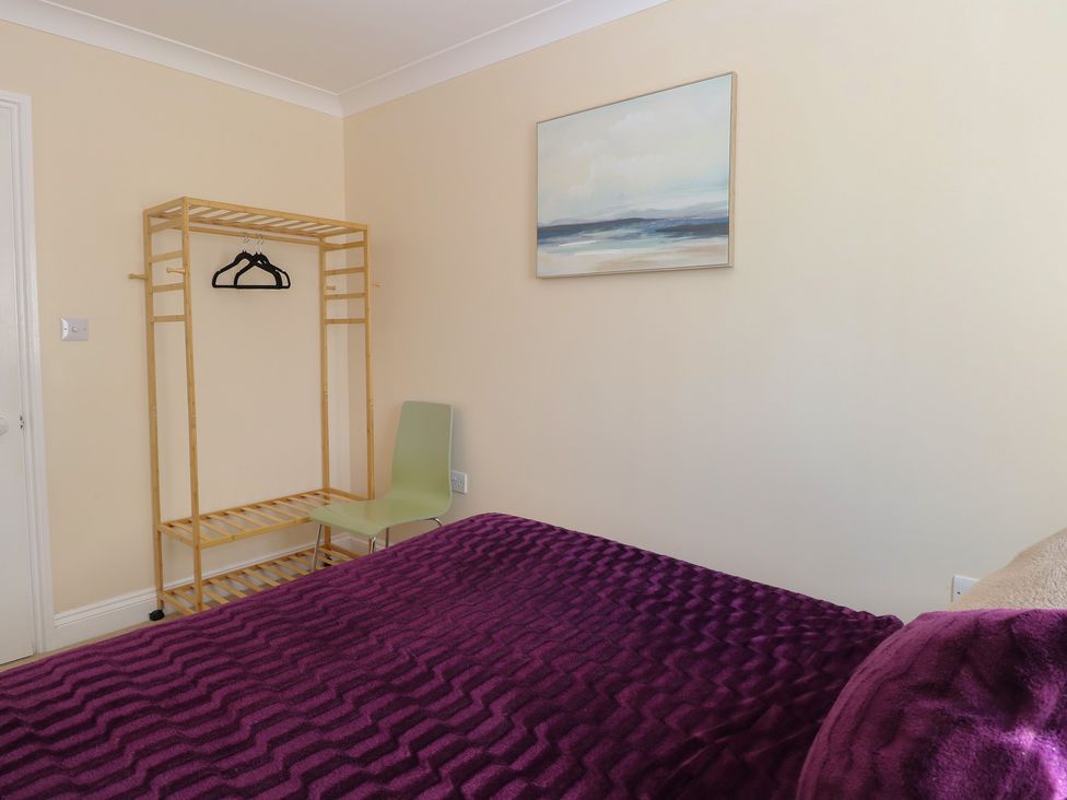 A bedroom with a bed and clothes rack at The Bungalow in Walcott
