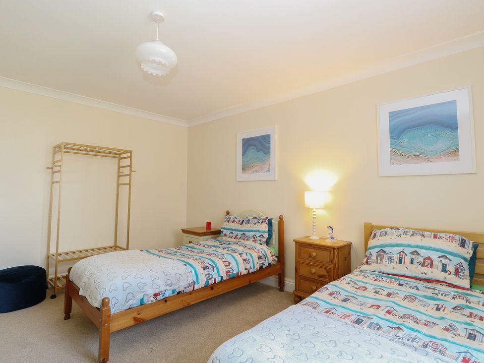 A bedroom with two beds and a lamp at The Bungalow in Walcott
