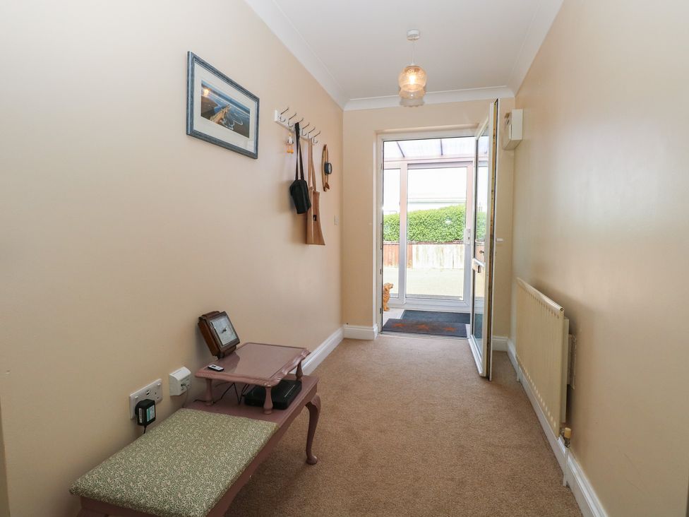 A hallway with a door and bench at The Bungalow in Walcott