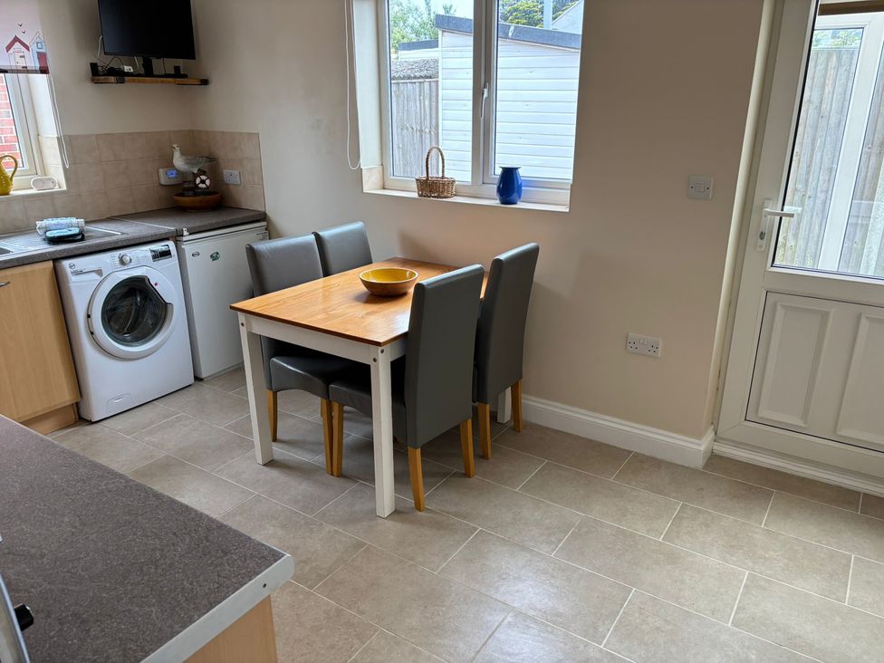 A kitchen with a dining table and chairs at The Bungalow in Walcott