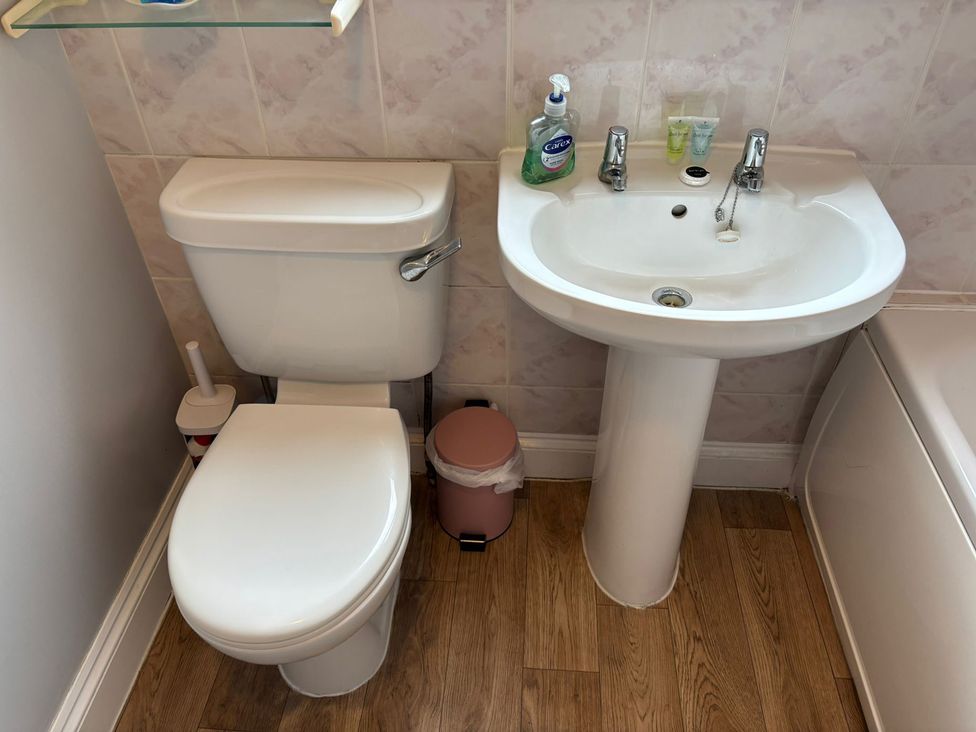 A bathroom with a toilet and sink at The Bungalow in Walcott