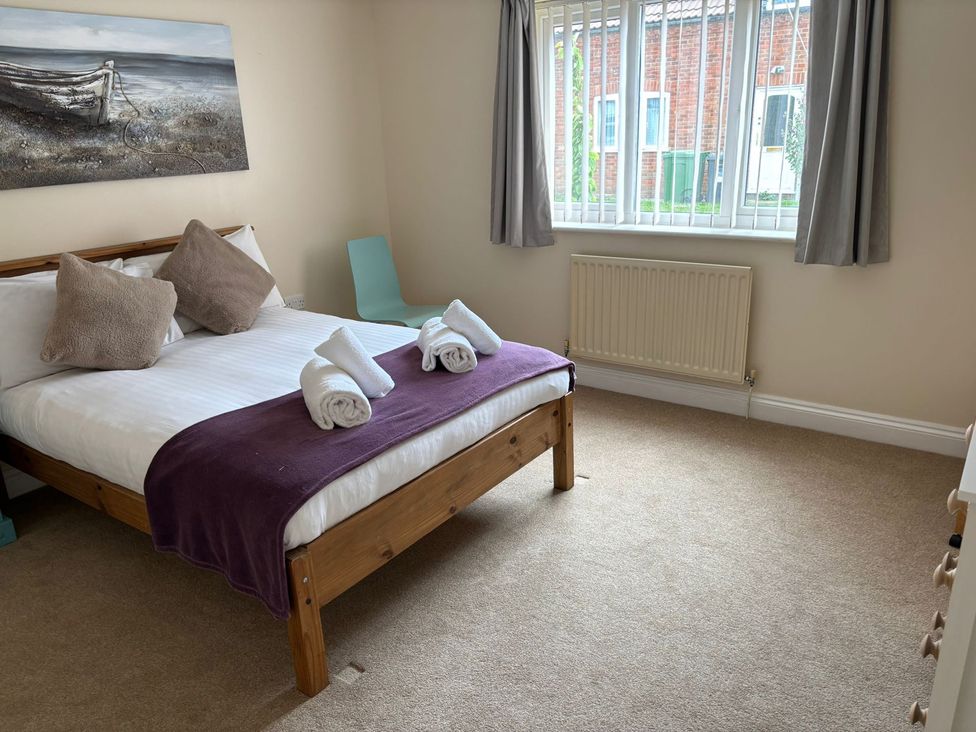 A bedroom with a bed and chair at The Bungalow in Walcott