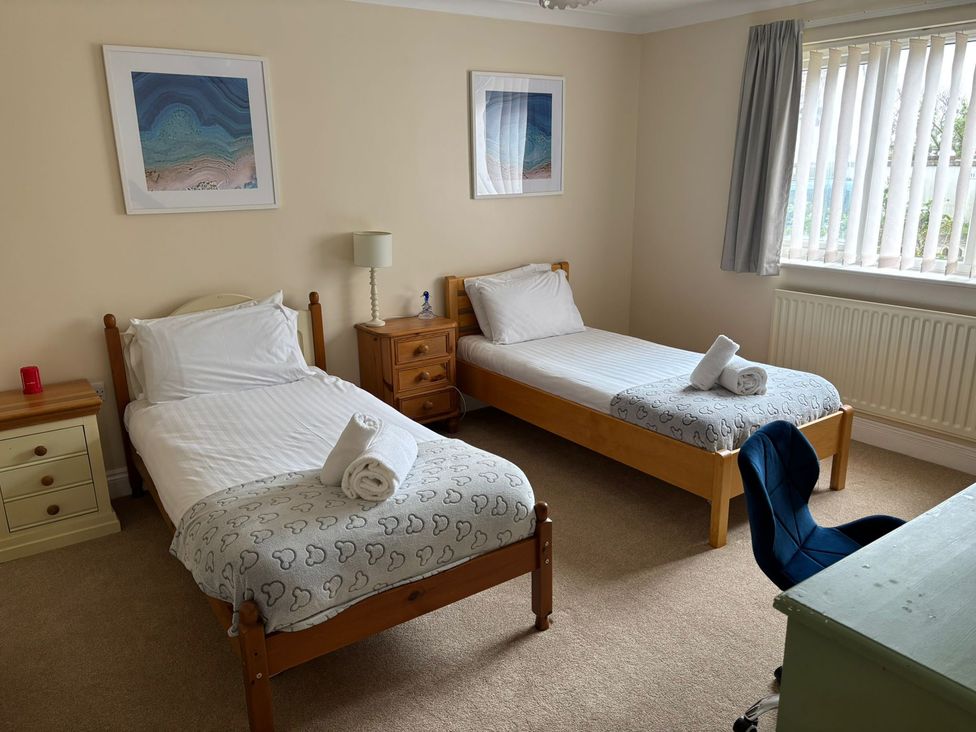 A bedroom with two single beds and a desk at The Bungalow in Walcott