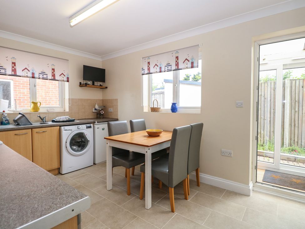 A kitchen with a table and chairs at The Bungalow in Walcott