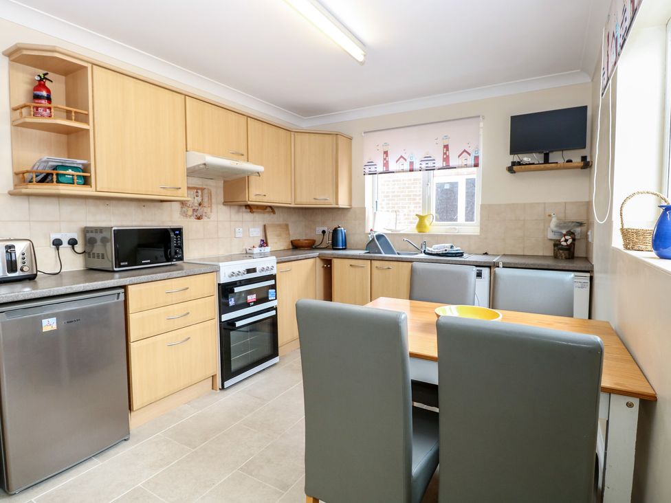 A kitchen with cabinets and appliances at The Bungalow in Walcott