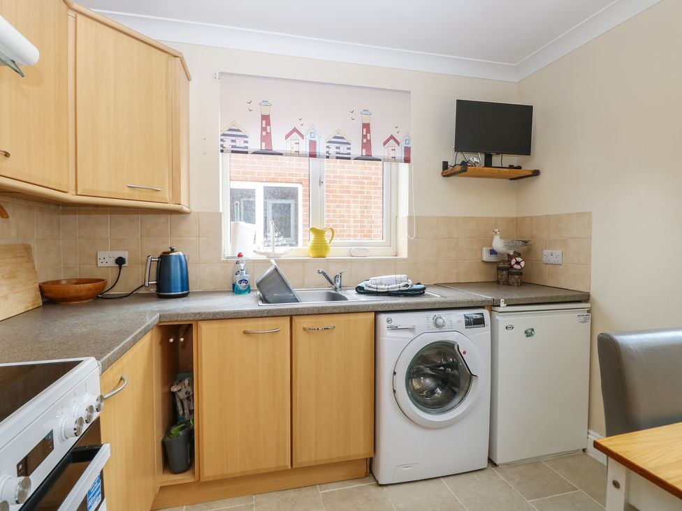 A kitchen with a washing machine and countertop at The Bungalow in Walcott