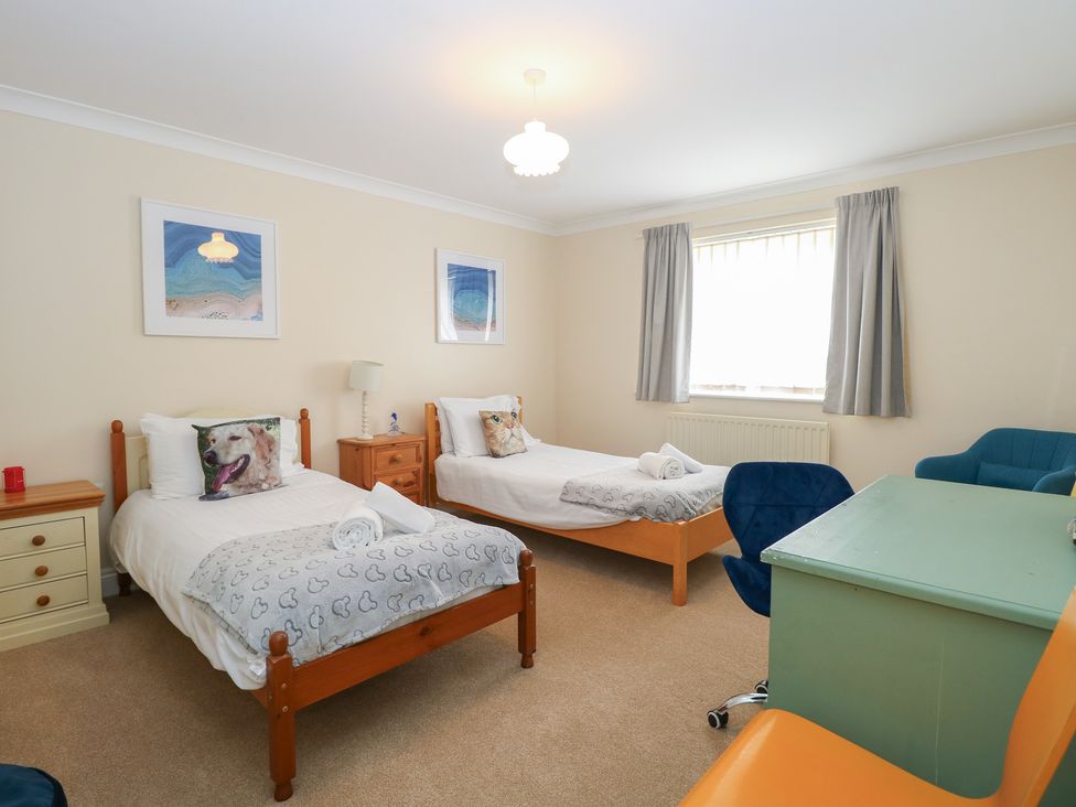 A bedroom with two beds and a desk at The Bungalow in Walcott
