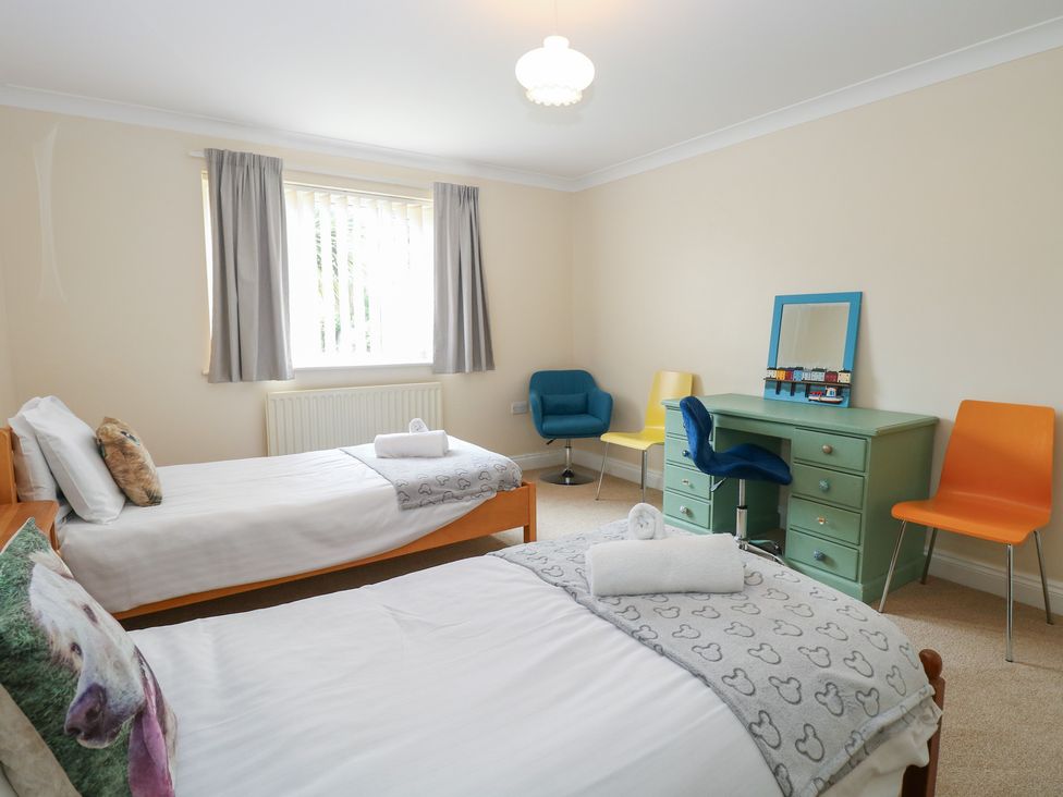 A bedroom with two beds and a desk at The Bungalow in Walcott