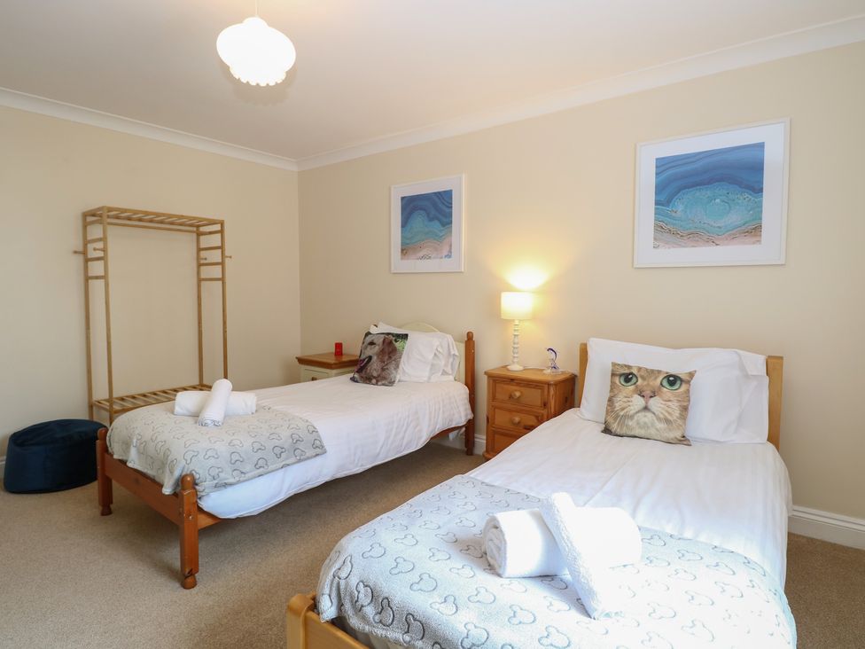 A bedroom with two beds, a lamp and a shelf at The Bungalow in Walcott