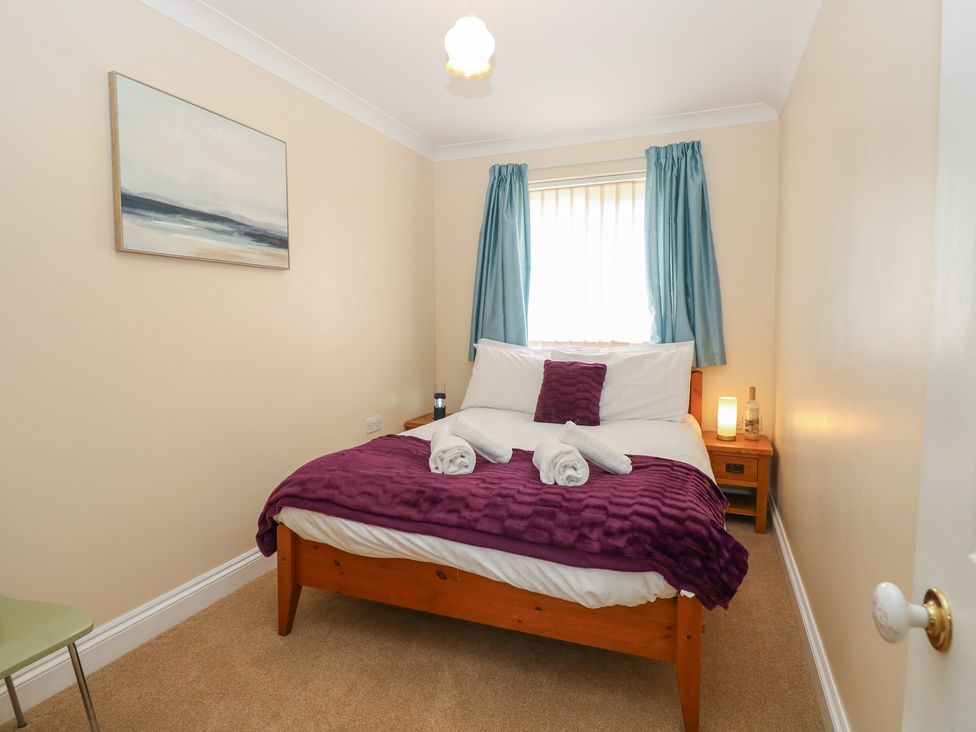 A bedroom with a bed and bedside table at The Bungalow in Walcott