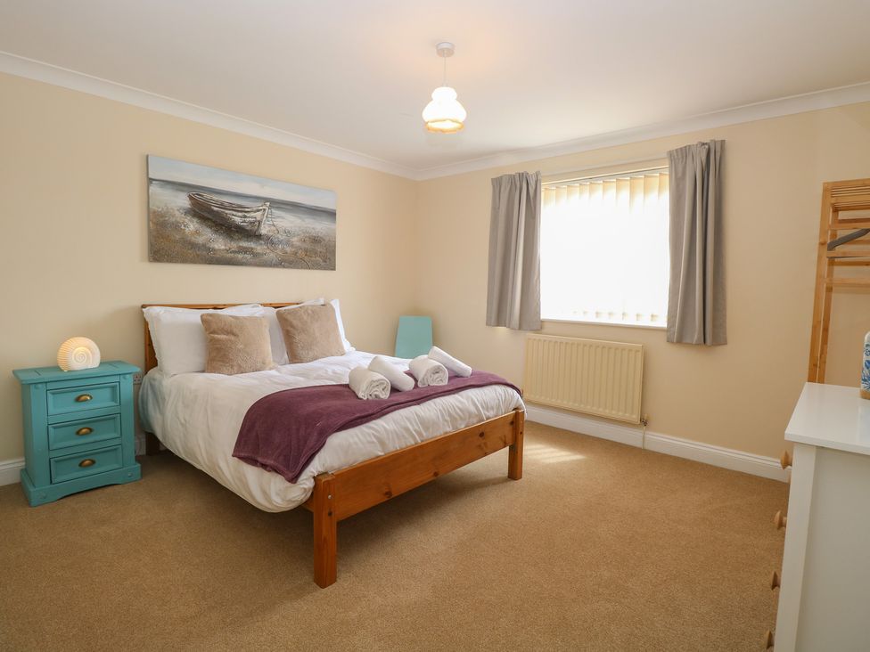 A bedroom with a bed and bedside table at The Bungalow in Walcott
