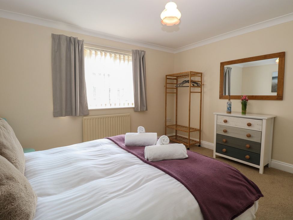 A bedroom with a bed and storage furniture at The Bungalow in Walcott