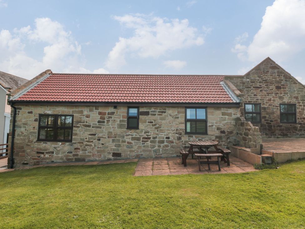 An outdoor space with a stone house and picnic table at The Calf House in Lingdale near Saltburn-by-the-Sea