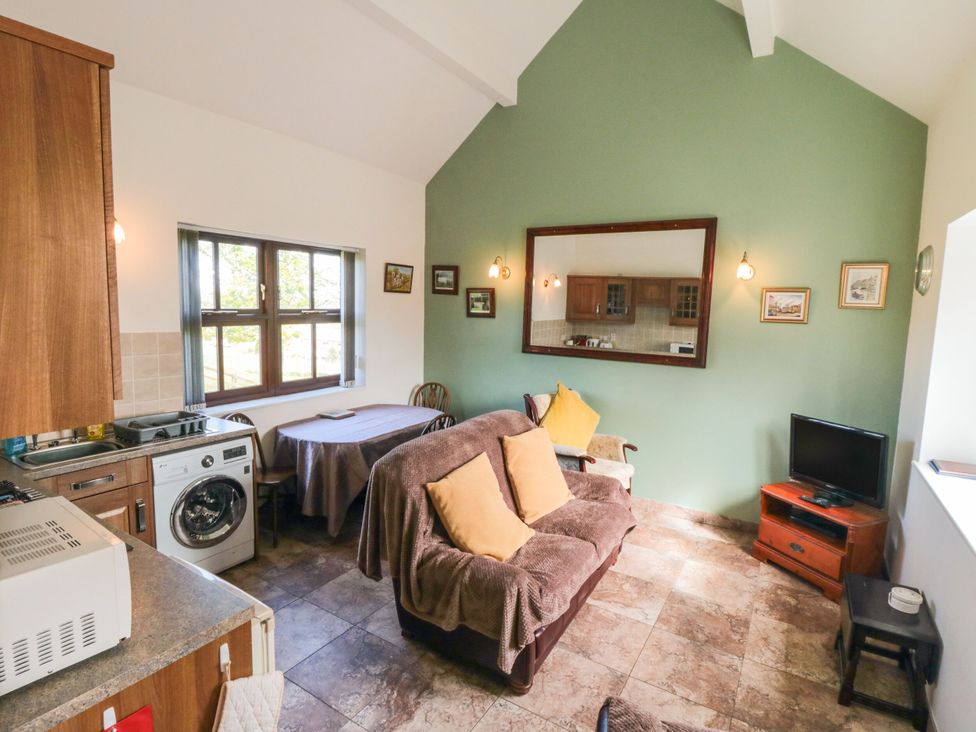 A living room with a kitchen area and a sofa at The Calf House in Lingdale near Saltburn-by-the-Sea