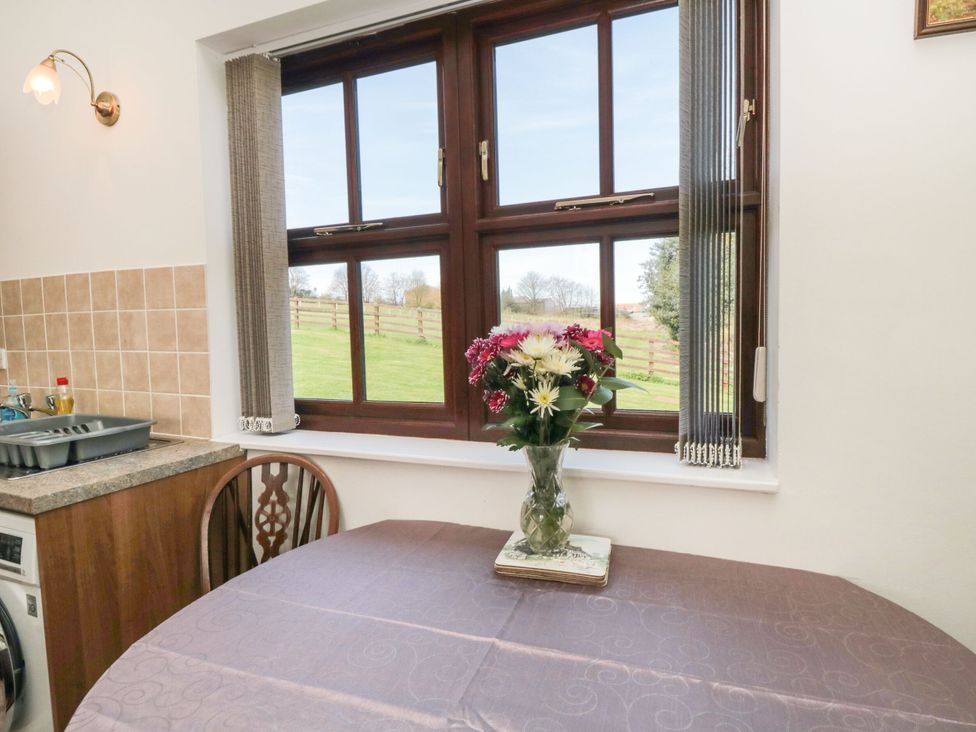 A dining room with a table and flower vase at The Calf House Lingdale near Saltburn-by-the-Sea