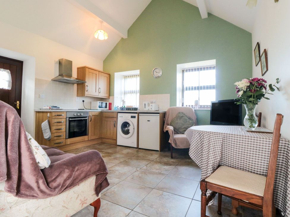 A kitchen with a table and chairs at The Cow Byre in Lingdale