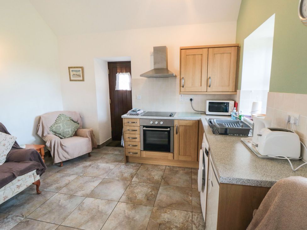 A kitchen with a sofa and kitchen appliances at The Cow Byre in Lingdale