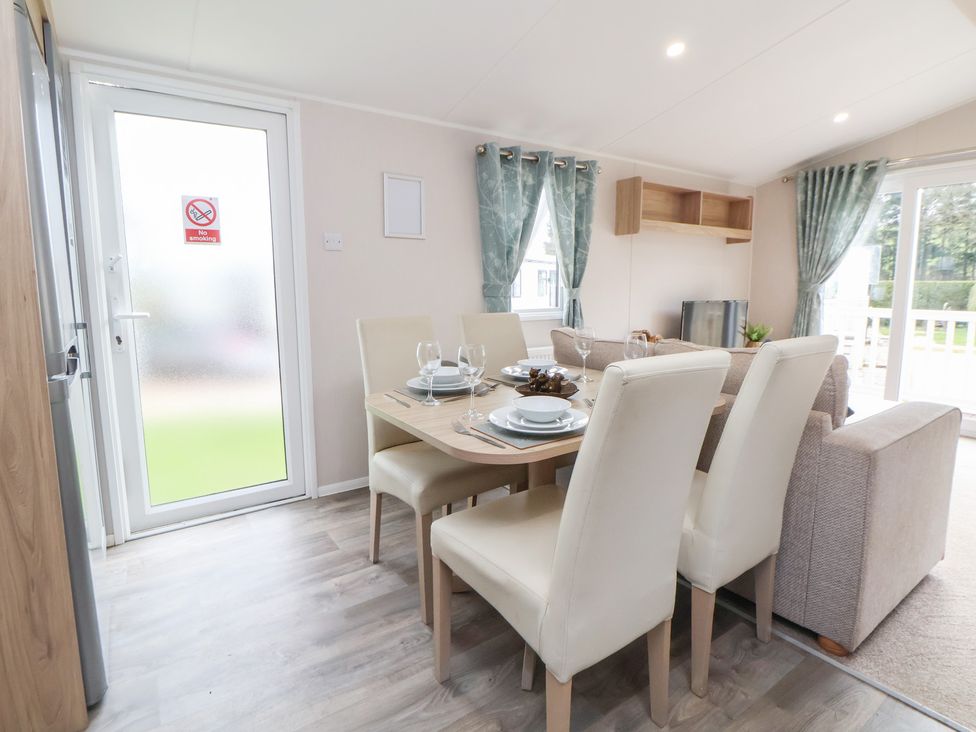 A dining room with a table set for meals at Willerby Malton 176 in Ruthin