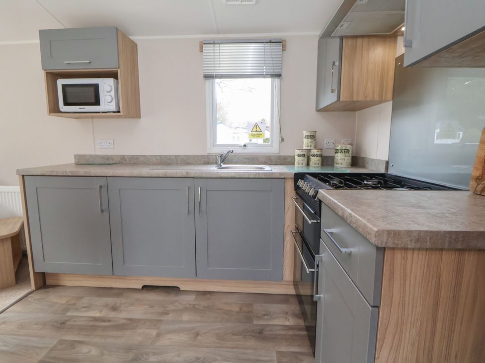 A kitchen with a microwave and gas stove at Willerby Malton 176 in Ruthin