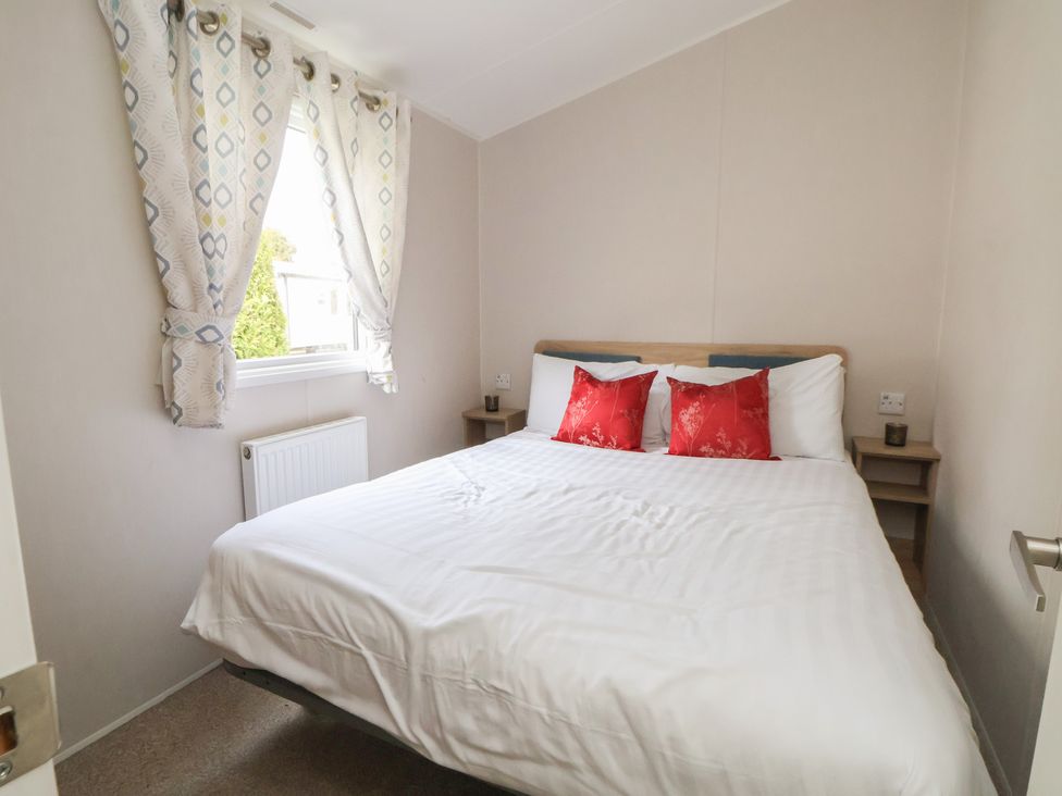 A bedroom with a bed and pillows at Willerby Malton 176 Ruthin