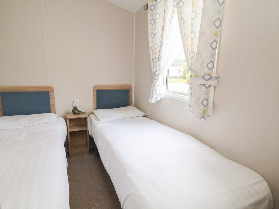 A bedroom with two beds and a window at Willerby Malton 176 in Ruthin