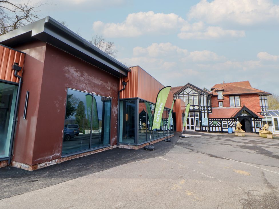 An outdoor view of two buildings with large windows and flags at Willerby Malton 176 in Ruthin