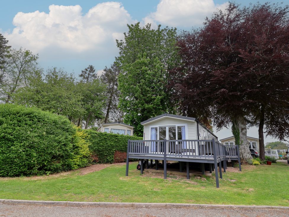 A holiday home with a deck surrounded by greenery at Willerby Malton in Ruthin