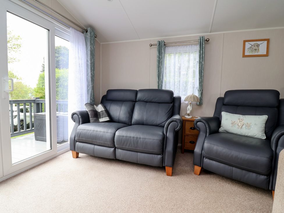 A living room with a sofa and lamp at Willerby Malton in Ruthin