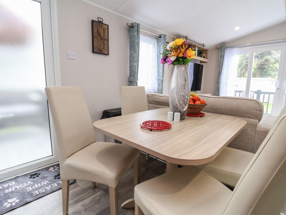 A dining room with a table and chairs at Willerby Malton in Ruthin
