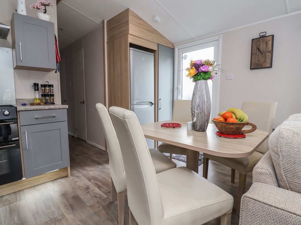 A dining room with a table and chairs at Willerby Malton in Ruthin