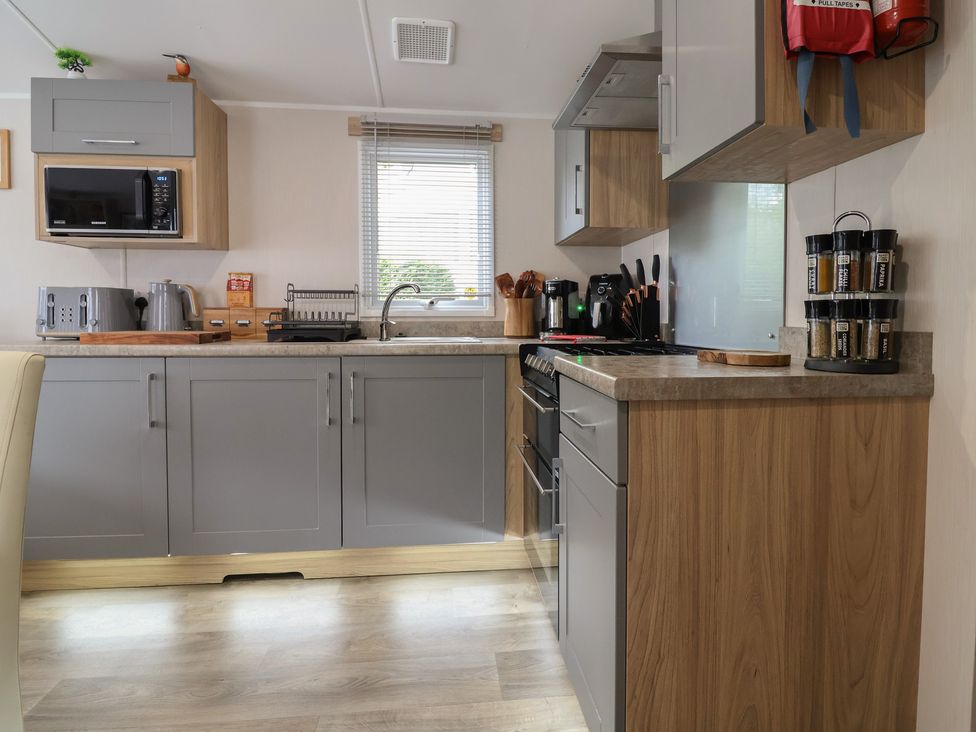 A kitchen with appliances and cabinets at Willerby Malton in Ruthin