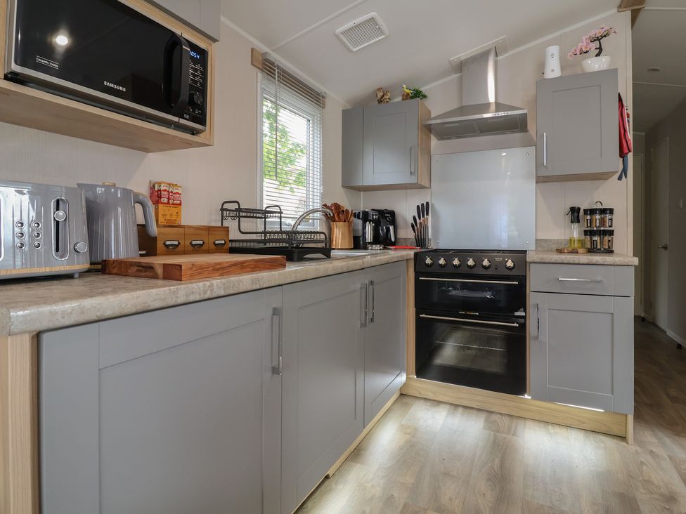 A kitchen with kitchen appliances and cabinets at Willerby Malton in Ruthin