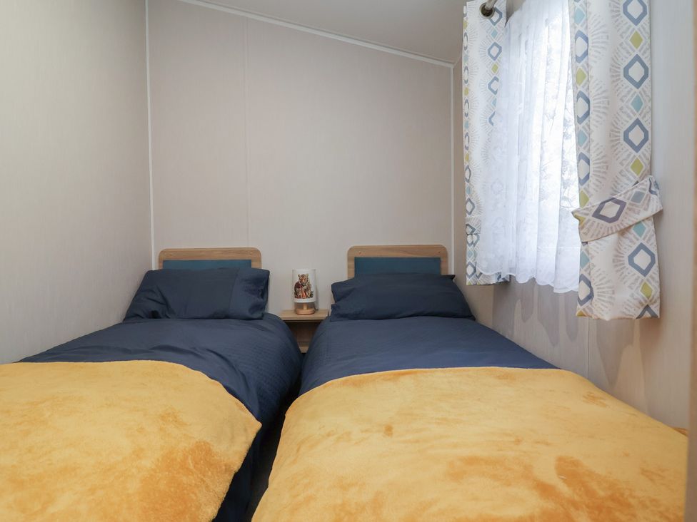 A bedroom with two single beds and a window at Willerby Malton in Ruthin