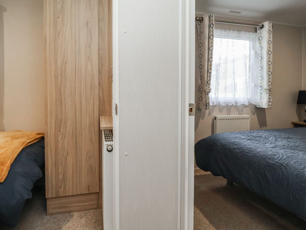 A bedroom with two beds and a window at Willerby Malton in Ruthin