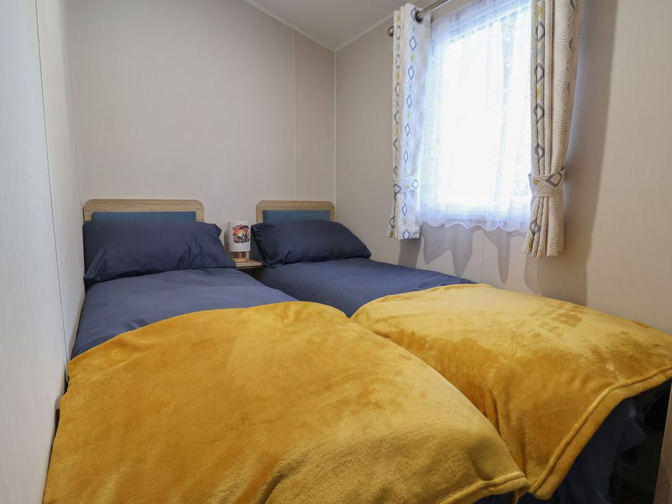 A bedroom with two beds and a window at Willerby Malton in Ruthin