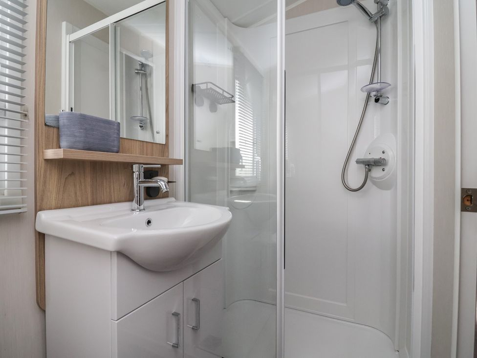 A bathroom with a sink and shower at Willerby Malton in Ruthin